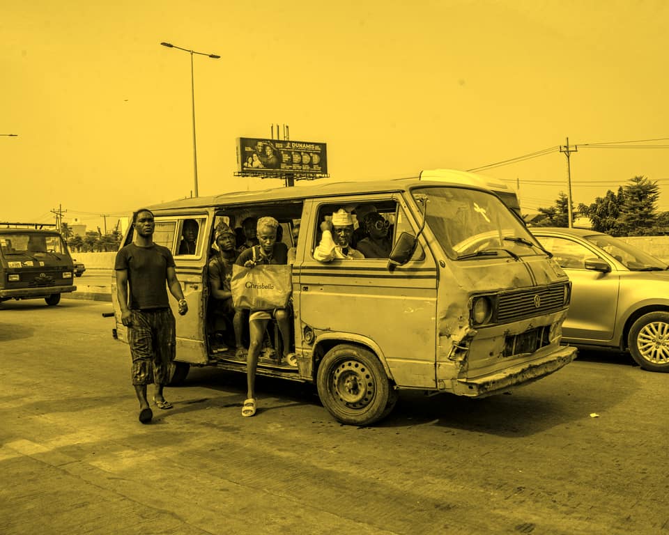 Commuters boarding a danfo through its open side door