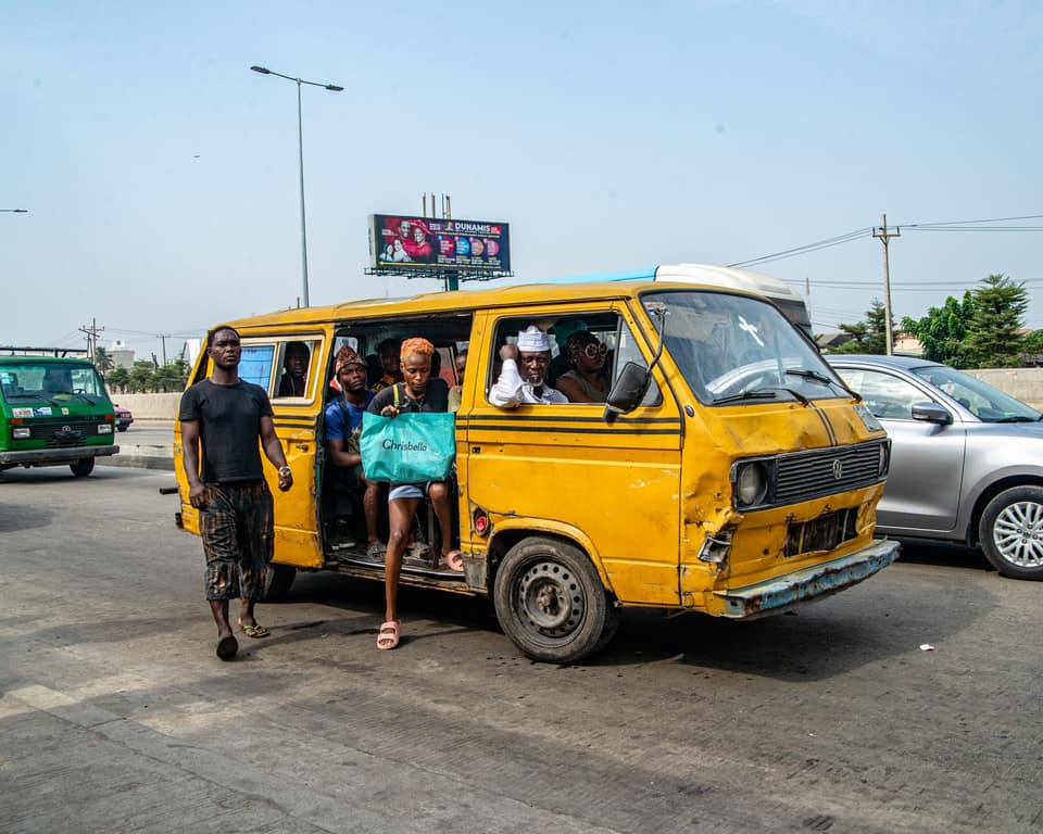 Commuters boarding a danfo through its open side door