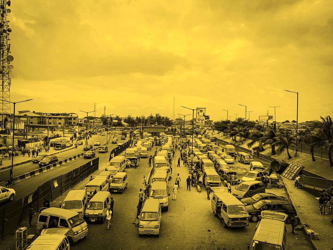 Aerial view of yellow danfos lined up along a Lagos road