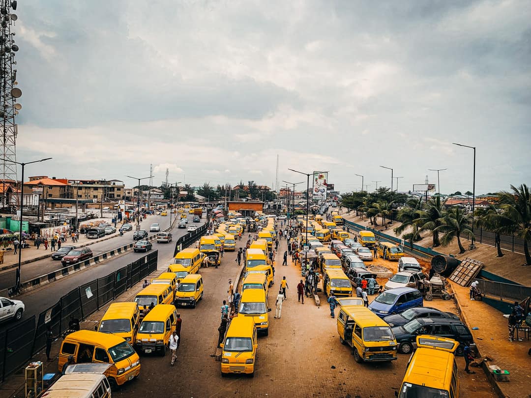 Aerial view of yellow danfos lined up along a Lagos road