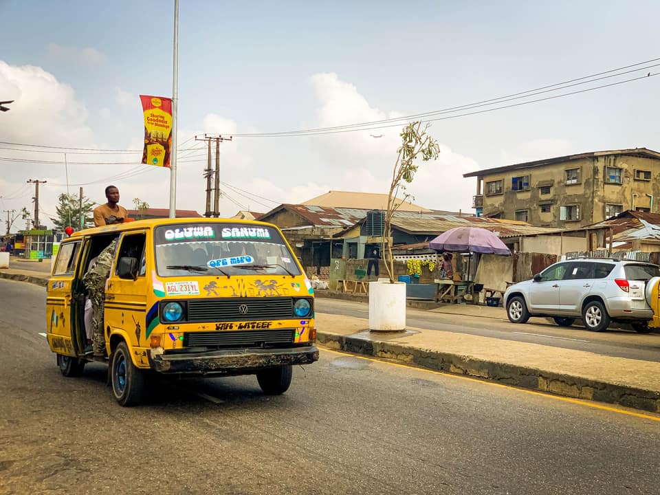 A yellow danfo with black stripes on a Lagos street