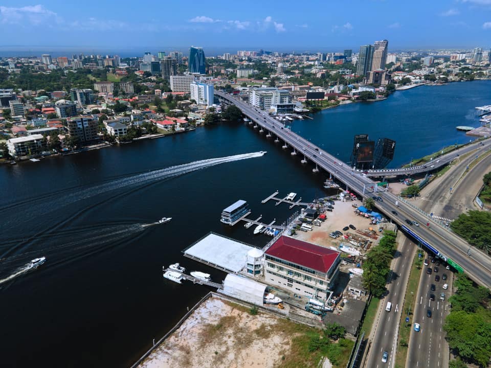 Aerial view of boats crossing the Lagos lagoon beside a bridge