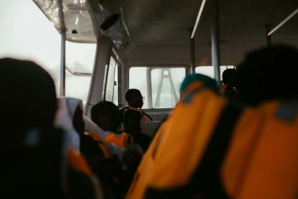 Passengers in orange life jackets on a Lagos ferry